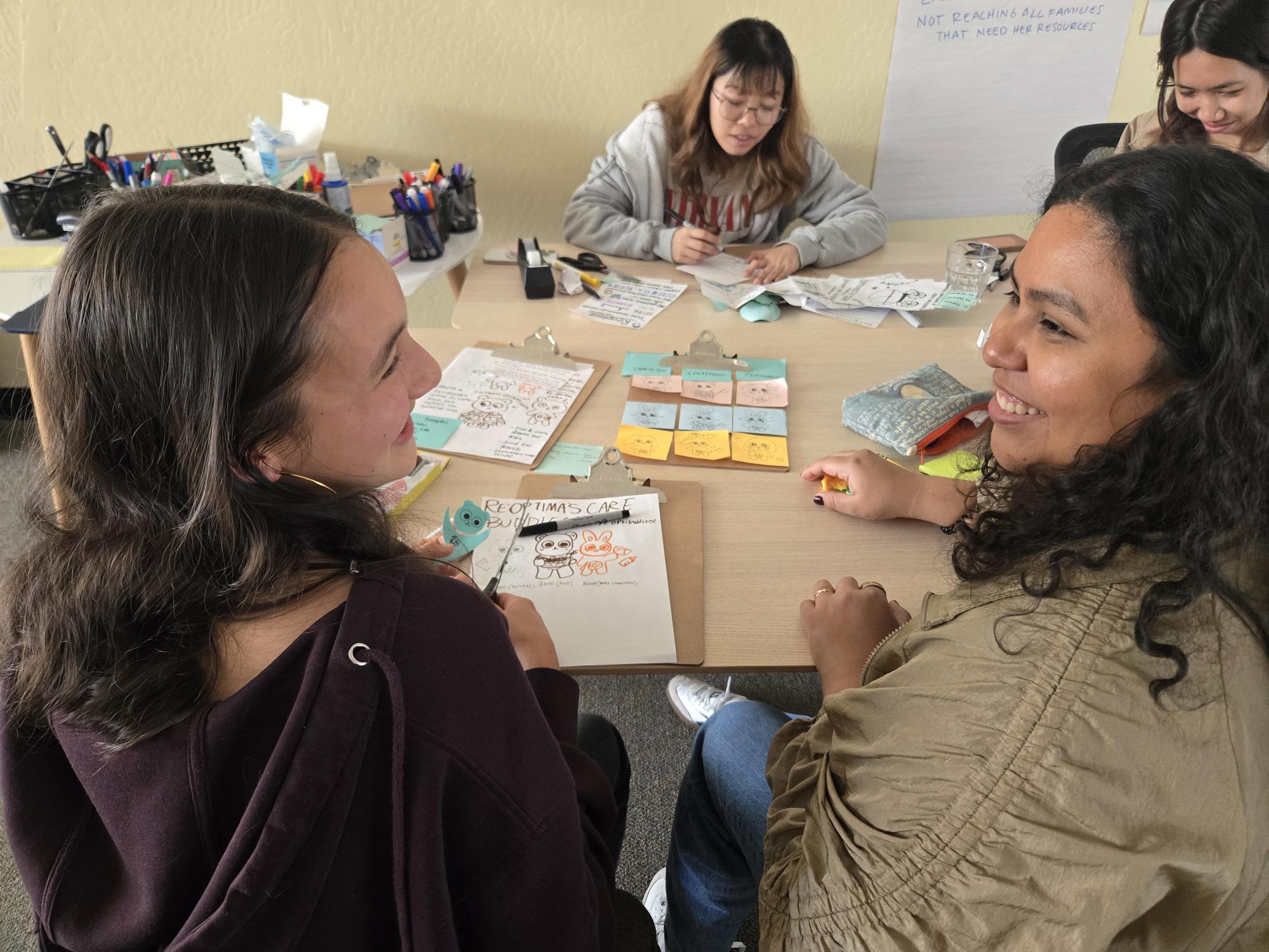 Accelerate scholars sit at a table ideating with sticky notes